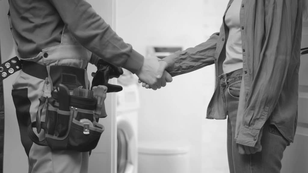 Plumber shaking hands with client